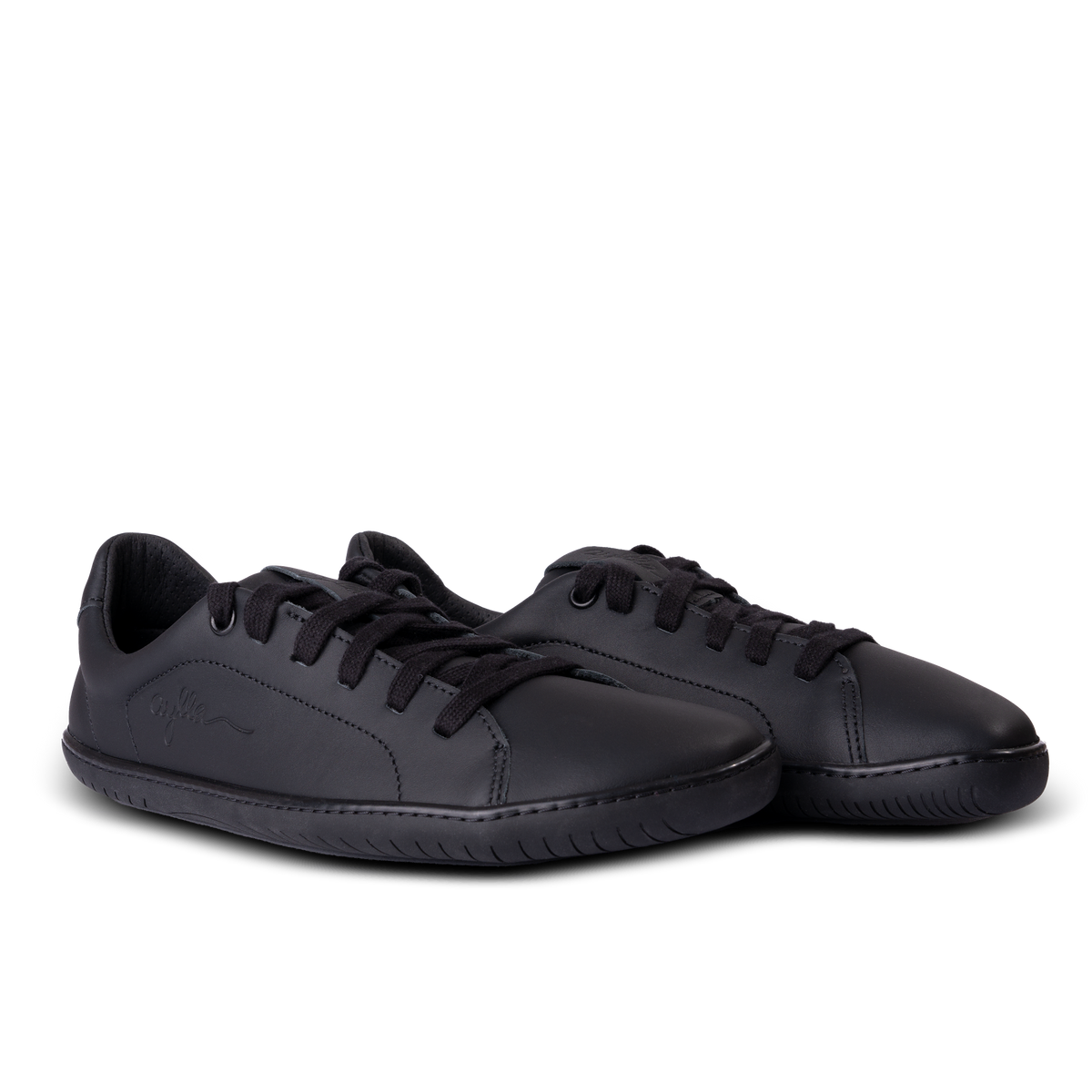 Par helsorte sneakers med sorte snørebånd skråt forfra