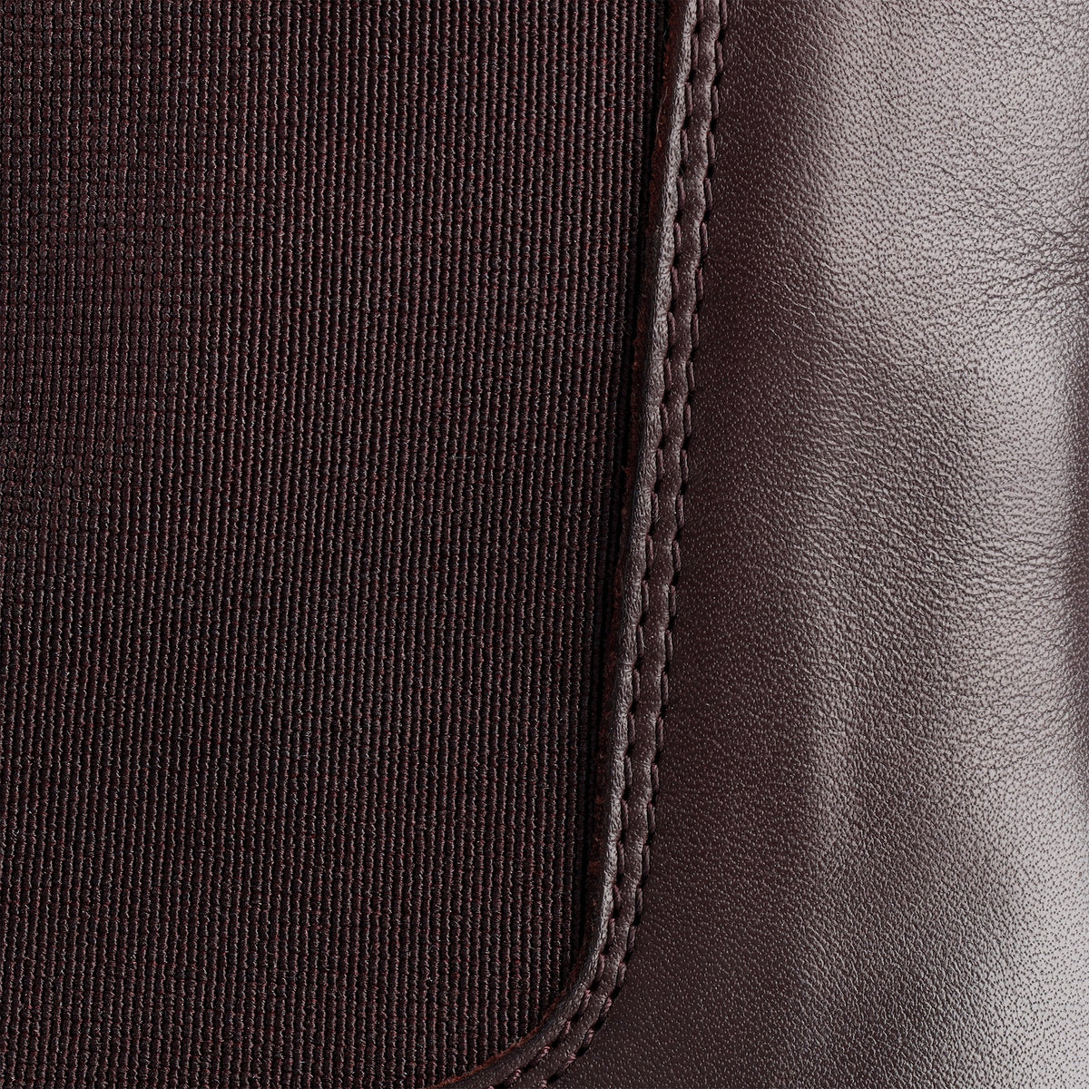 Nærbillede af elastisk sidepanel og syning mod blankt bordeaux nappalæder