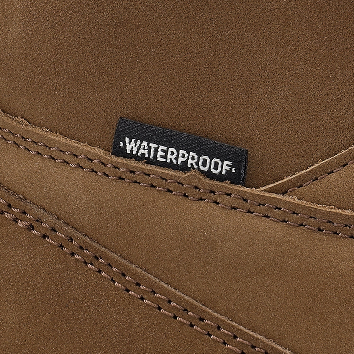 Nærbillede af dobbelte syninger og WATERPROOF-mærke på brunt nubuckskind