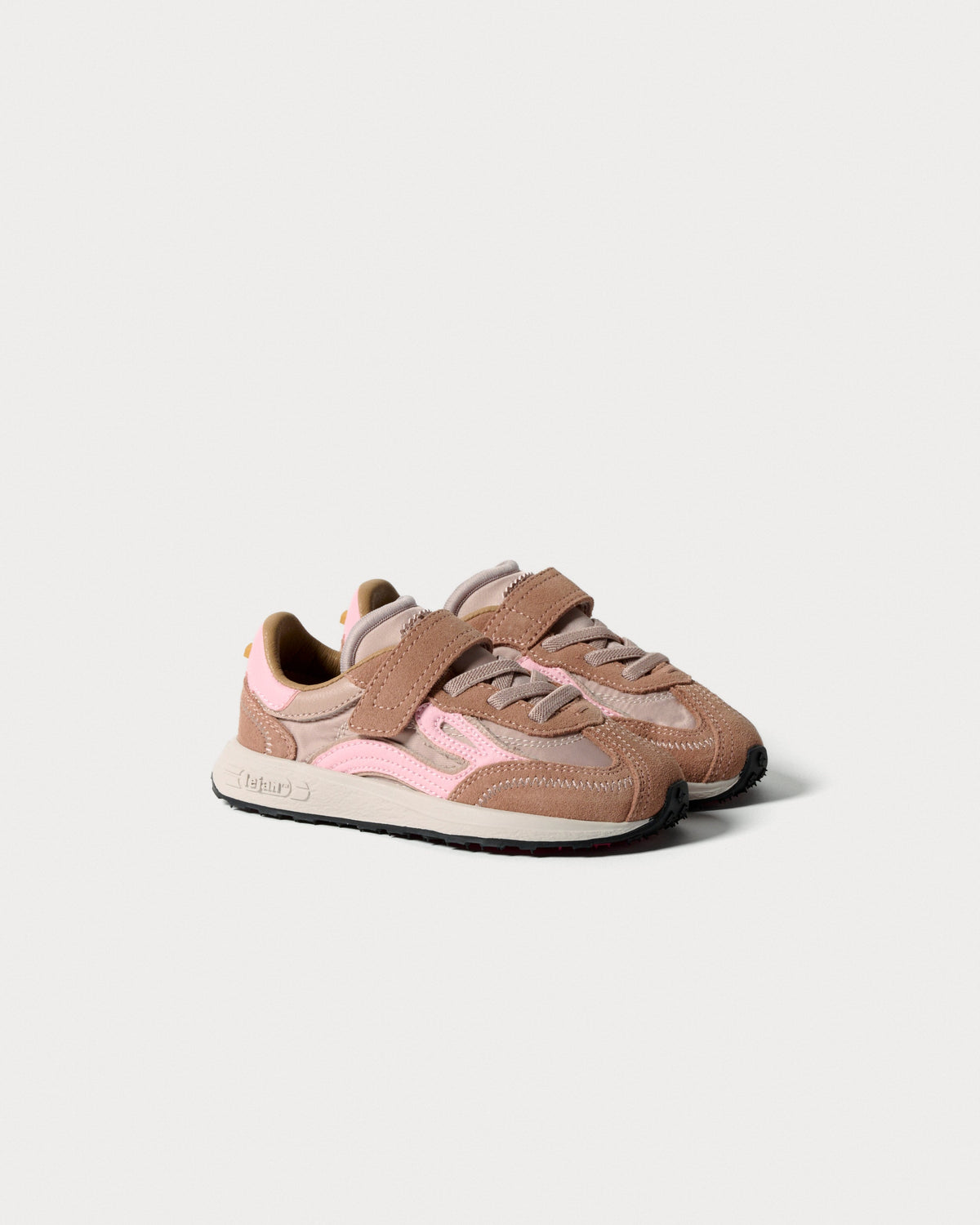 Par rosa børnesneakers med velcrorem og snørebånd set skråt forfra