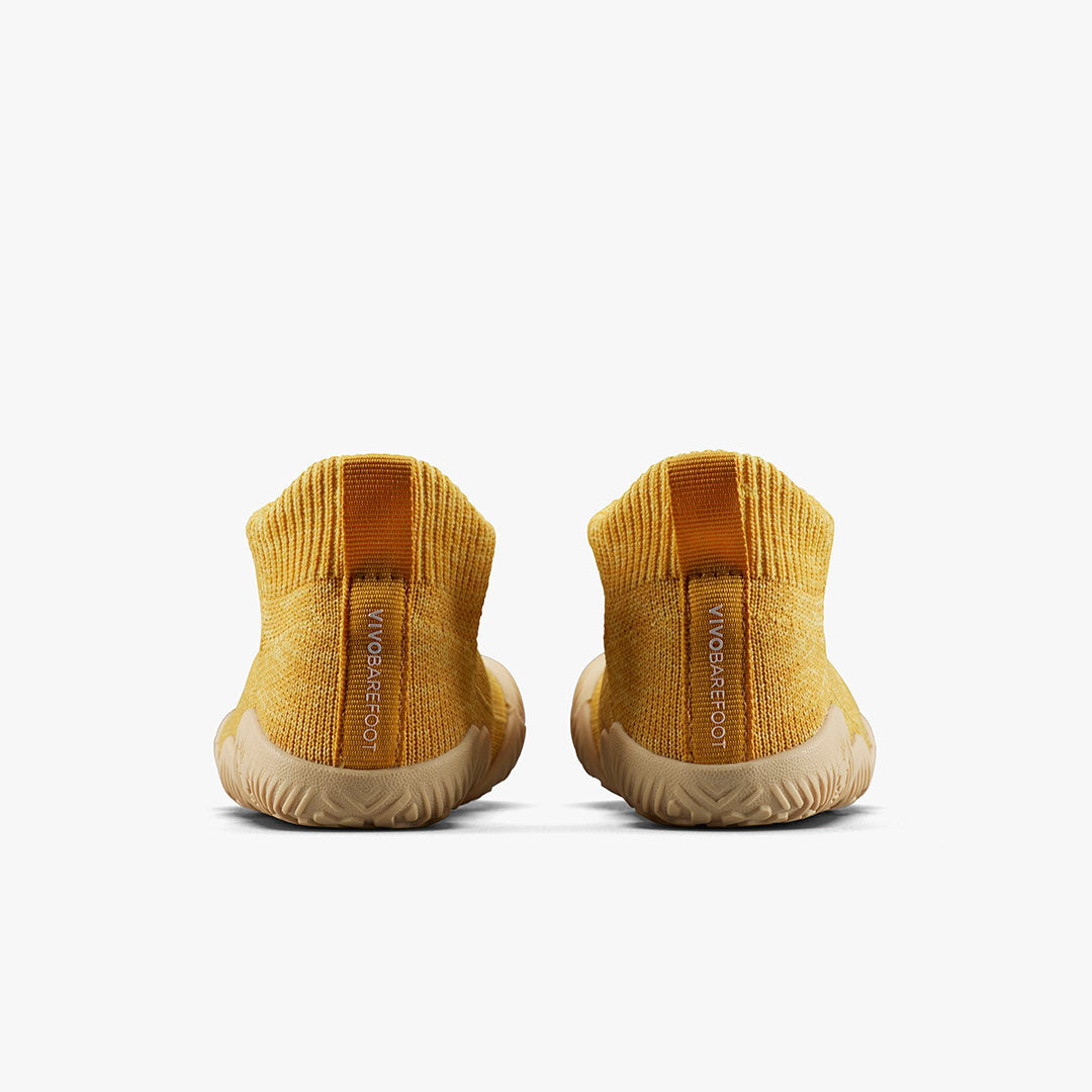 Bagfra visning af Vivobarefoot Pluma Knit Toddlers sko i Honey Gold med strømpelignende konstruktion og hælstrop for nem påtagning. Designet til barfodsfølelsen.