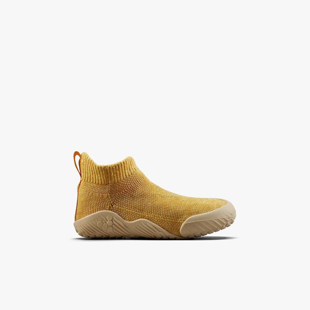 Vivobarefoot Pluma Knit Toddlers sko i Honey Gold set fra siden. Barfodsvenligt design med terrakottafarvet, sømløst strikoverdel og en fleksibel, tynd ydersål.