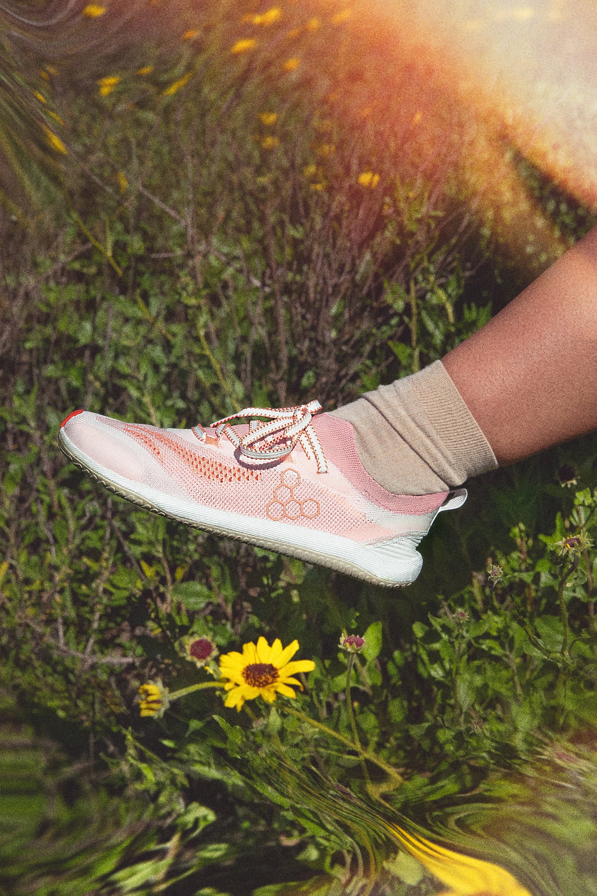Strikket barfodssko på fod i græs med gule blomster