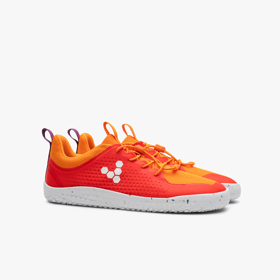 Vivobarefoot Primus Sport III Juniors barfodssko, variant Cherry Tomato, i orange-rød med hvid sål og honningmønster, designet til komfort og bevægelsesfrihed.
