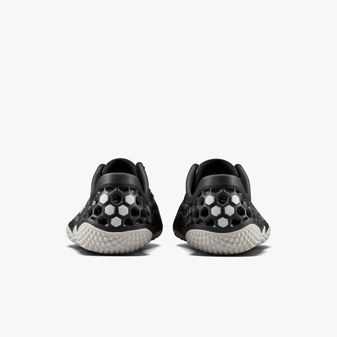 Vivobarefoot Ultra IV Womens sneakers i varianten Obsidian set bagfra. Sorte sko med honningkagemønster og hvide detaljer, typisk minimalistisk barfodsstil for fleksibilitet.