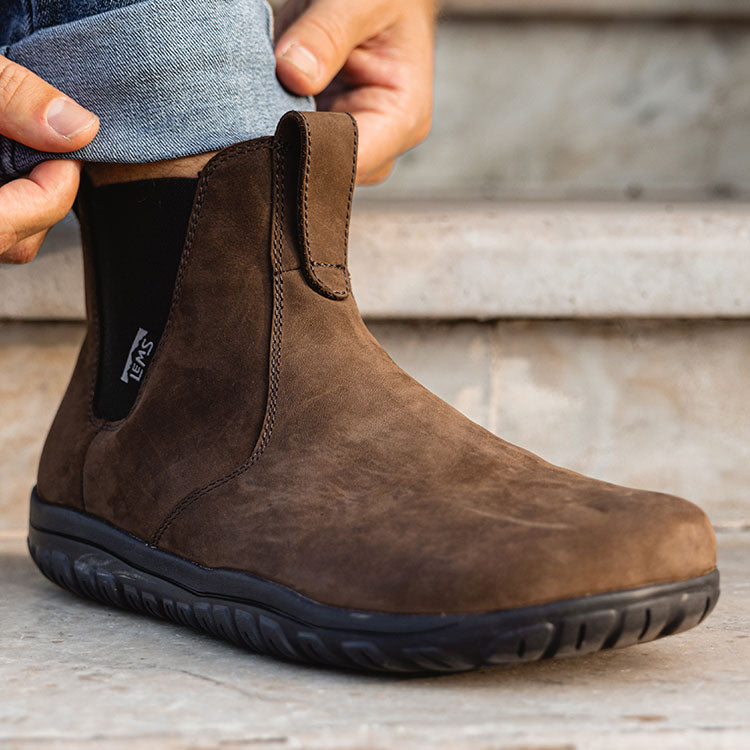 Lems Chelsea Boot Waterproof i varianten Espresso. Brun støvle med elastiske sidepaneler og sort gummisål, båret sammen med opkørte jeans, ideel til både afslappet og vejrbestandig brug.