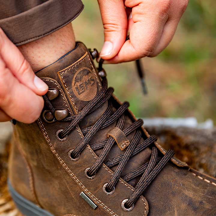 Lems Boulder Boot Grip Waterproof i Dakota variant ses i brun læder med kraftige snørebånd. Bæres og snøres tæt, perfekt til udendørs brug. Unisex design, vandtæt og minimalistisk.