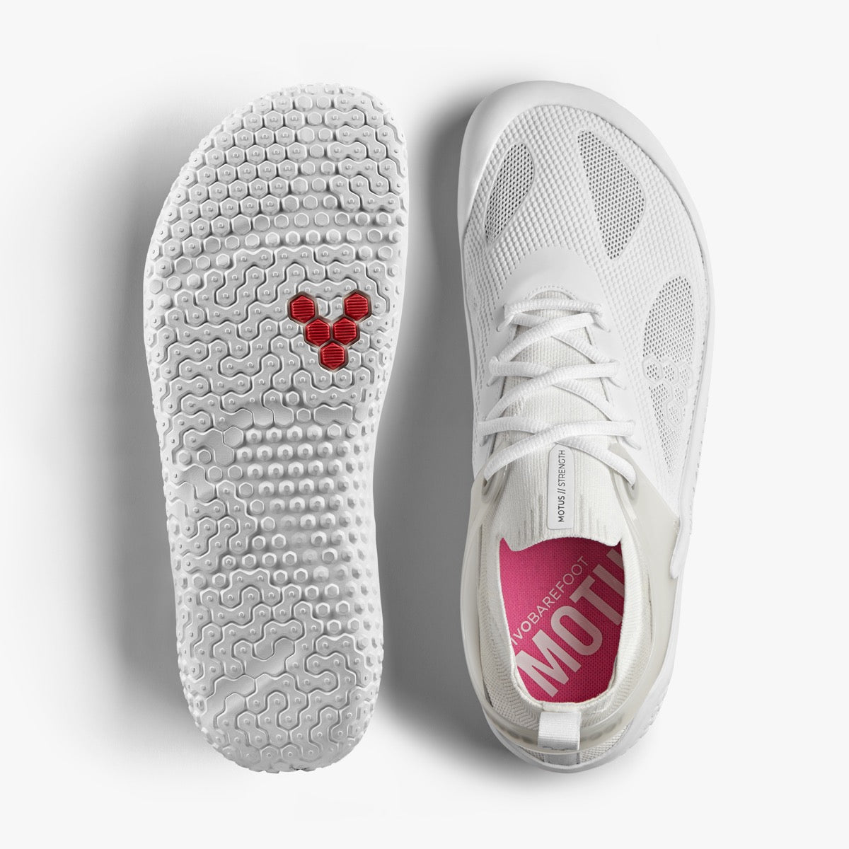 Vivobarefoot Motus Strength Womens i Bright White, viser både overside og sål. Skoen er designet til barfodstræning, lett og fleksibelt med en 2mm sål med grebende knopper og åndbar maskeoverdel.