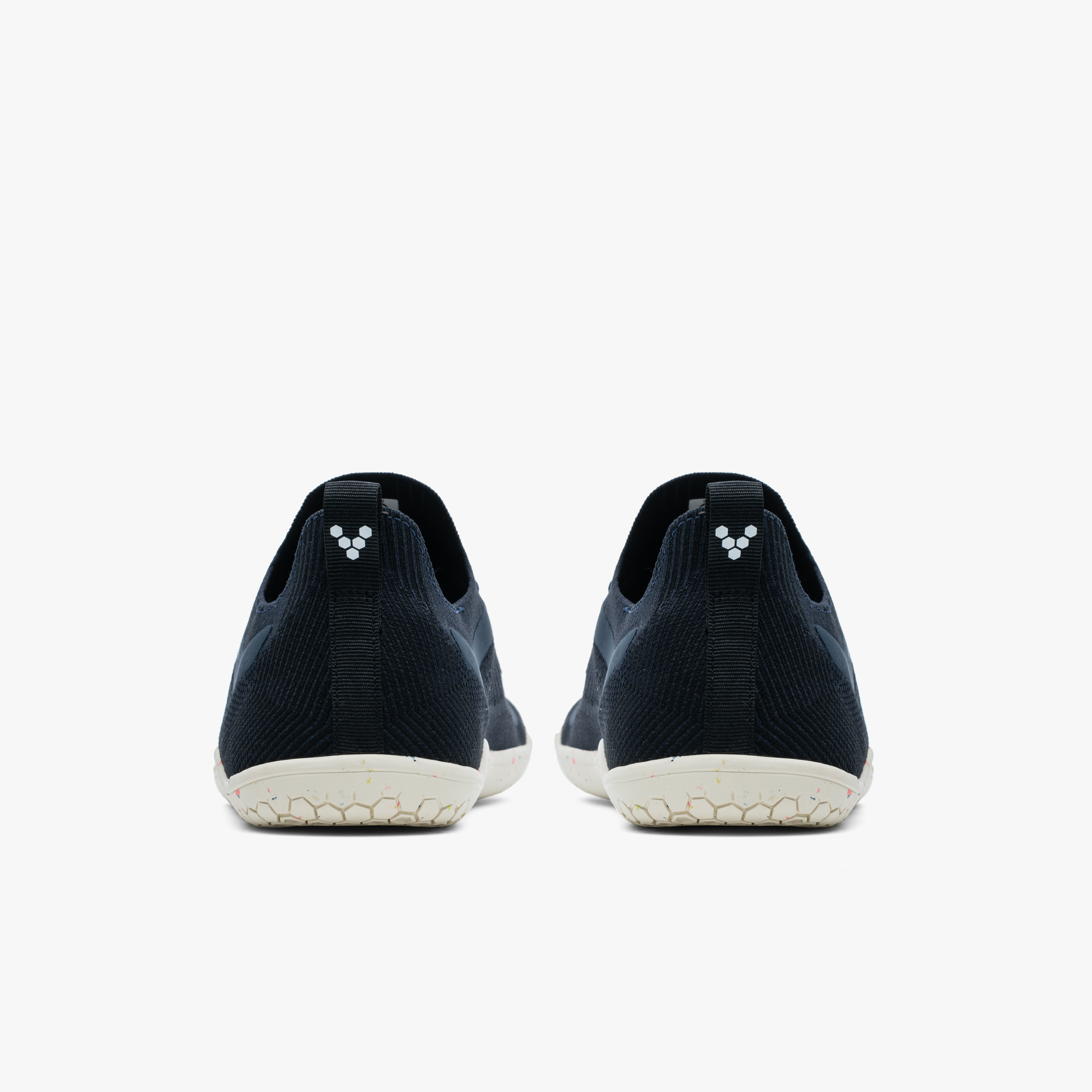 Vivobarefoot Primus Lite Knit Mens løbesko i varianten Midnight. Skoene er vist bagfra, udstyret i mørkeblå med Vivo-logo på hælfligene og flade, off-white såler designet til naturlig fodbevægelse og jordfornemmelse.